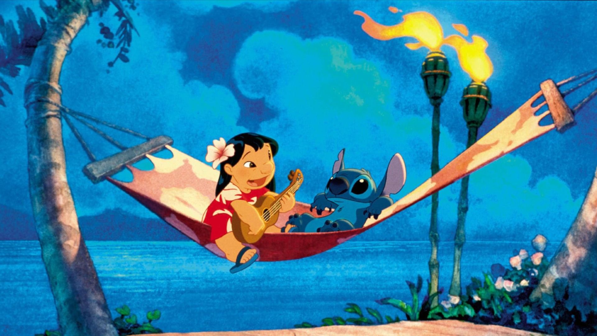 A girl in a red dress and a blue creature with big ears are lying in a hammock