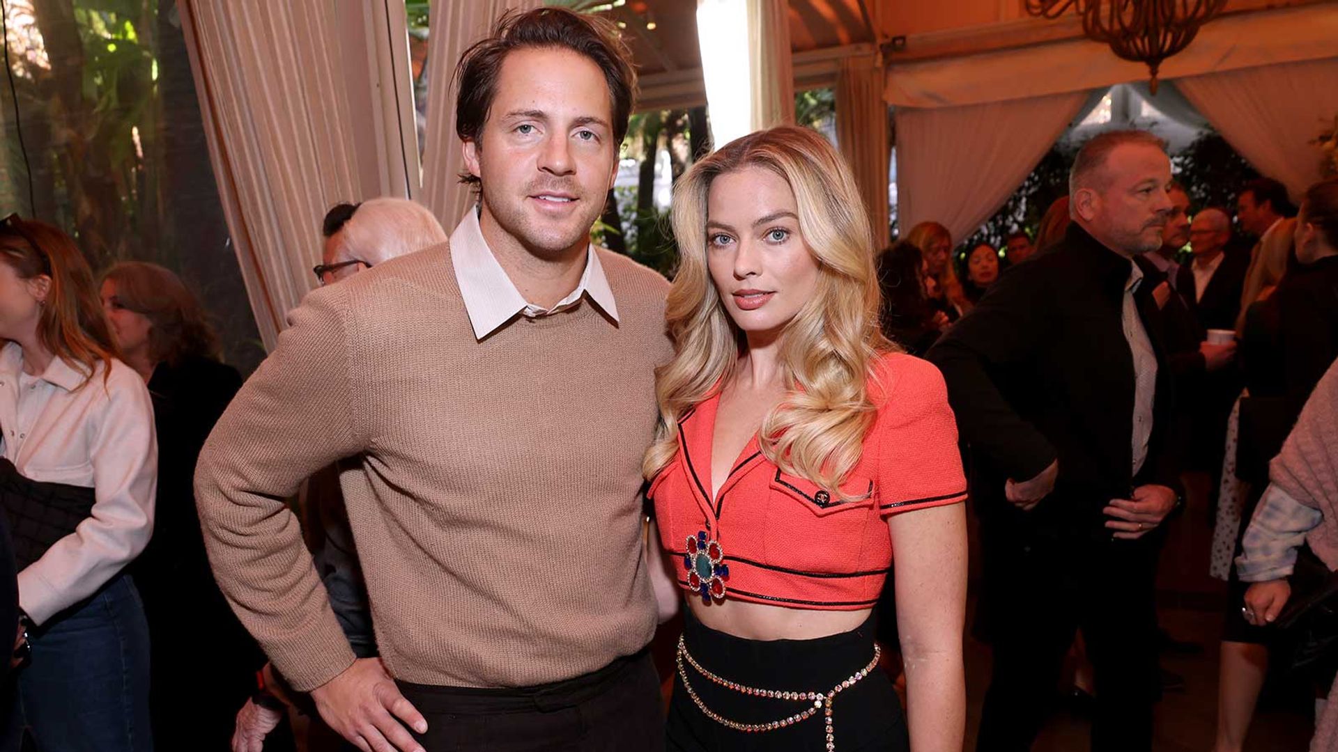 Tom Ackerley and Margot Robbie pose together at a social event