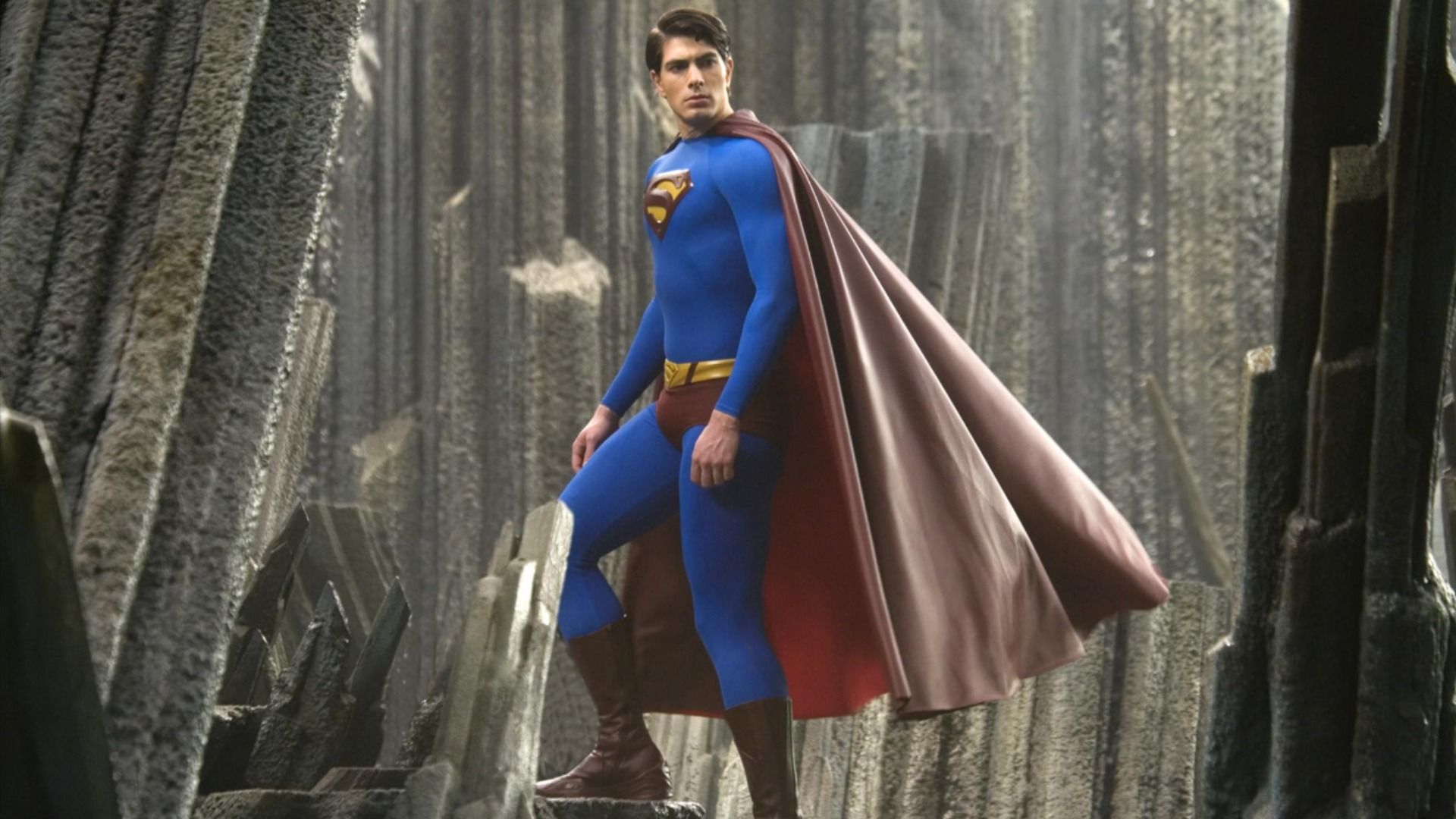 Actor Brandon Routh in a blue and red superhero costume with the letter S on his chest climbs up the stairs