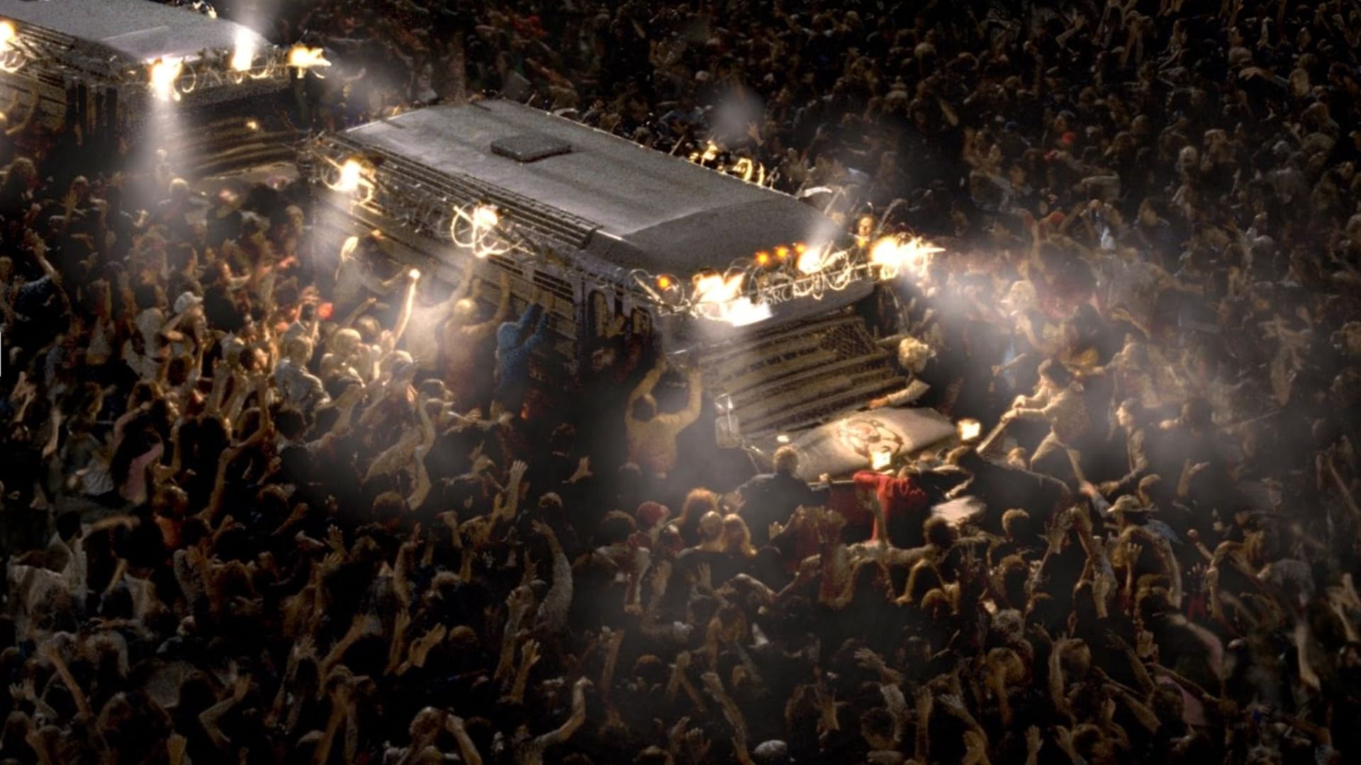 Zombie hordes surrounding a white truck at night