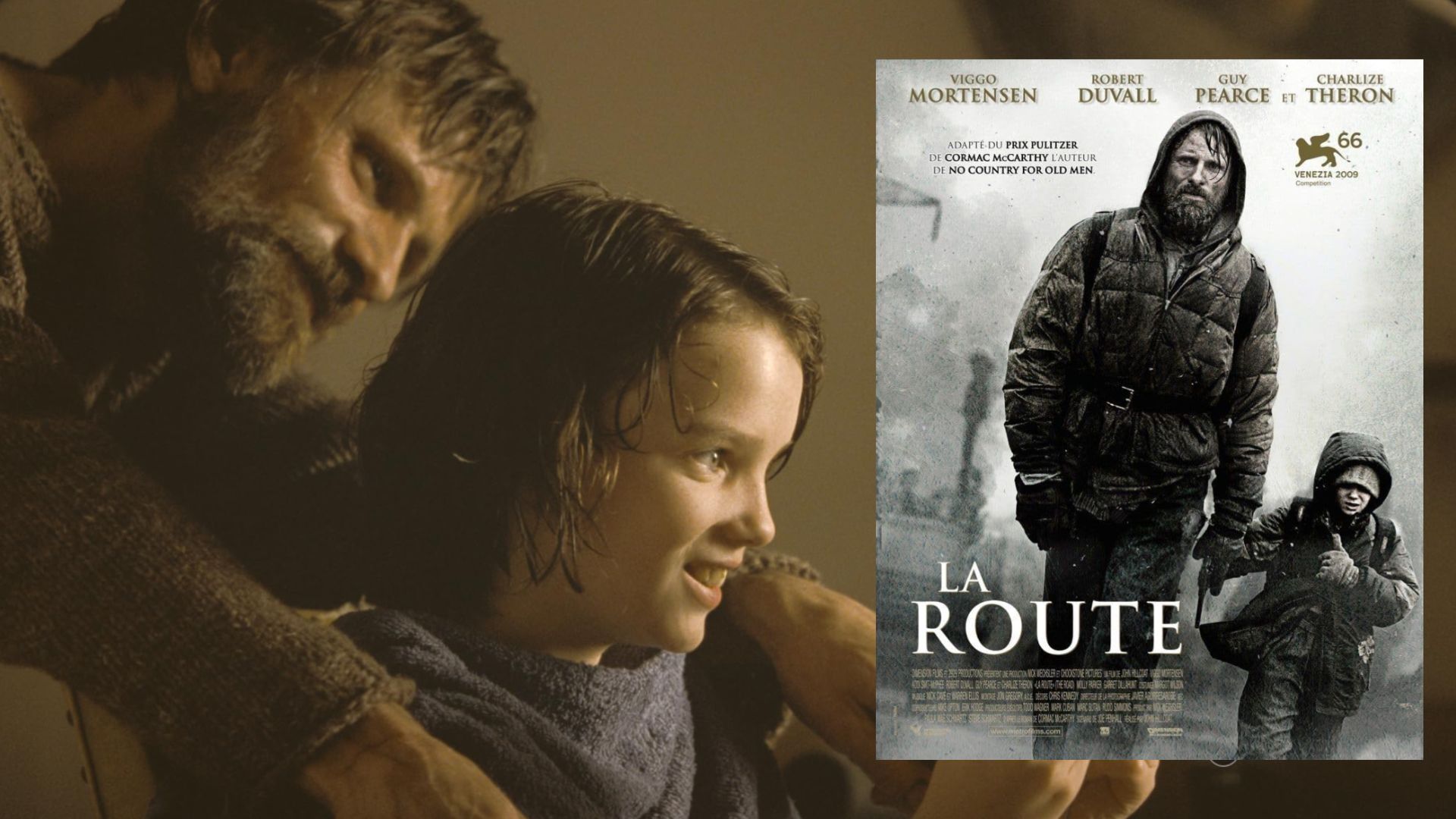 Actor Viggo Mortensen in a gray sweater sits next to a child, nearby is a movie poster showing the actor walking down the street with a child