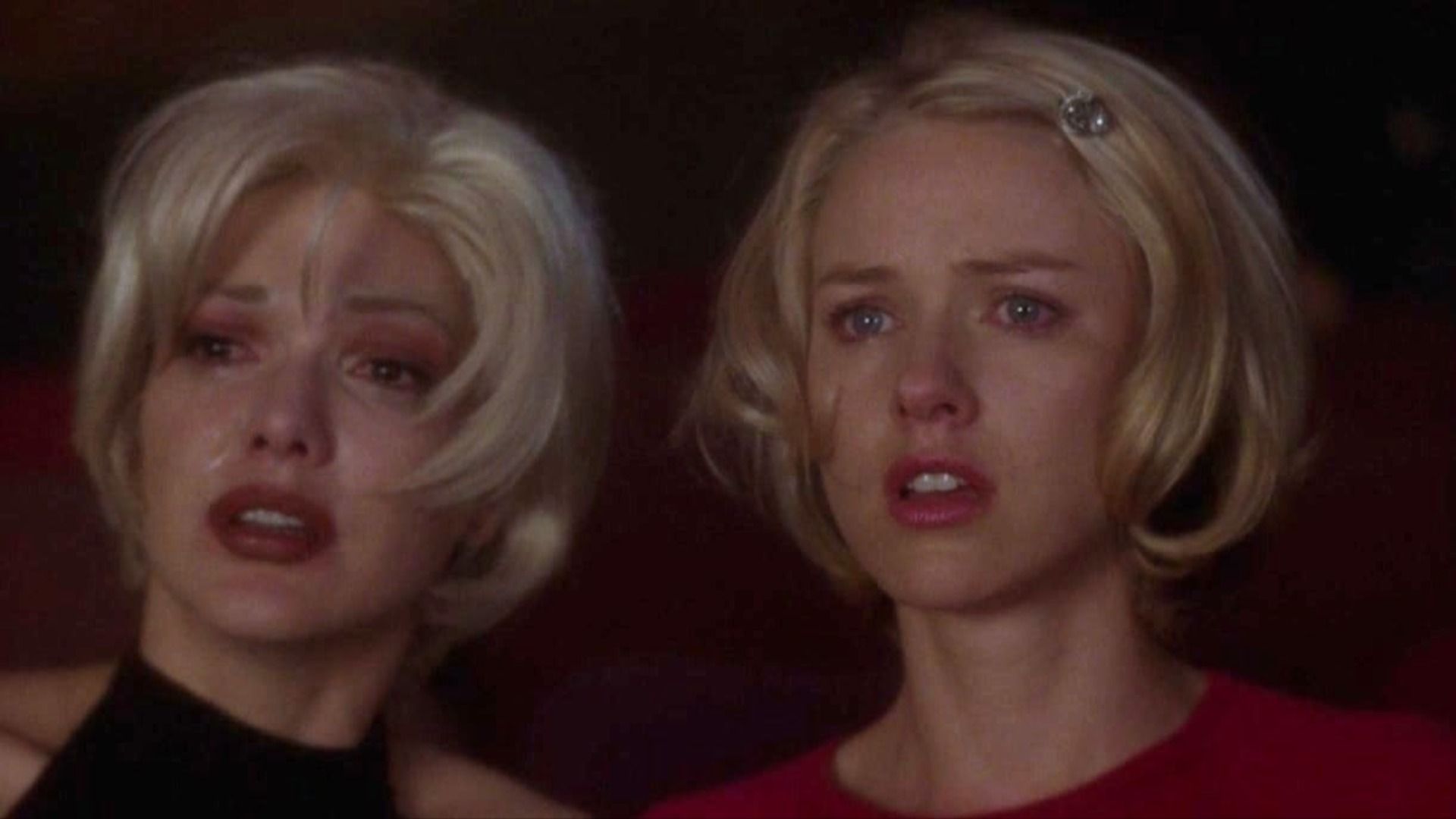 A white-haired girl in black clothing is crying while a white-haired girl in red clothing has her mouth open in surprise