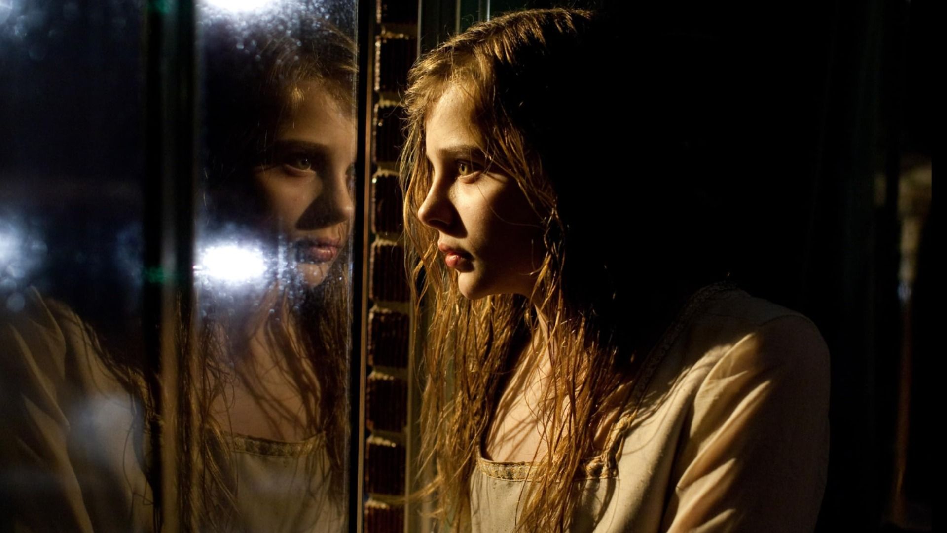Actress Chloë Grace Moretz looks at her reflection in the window
