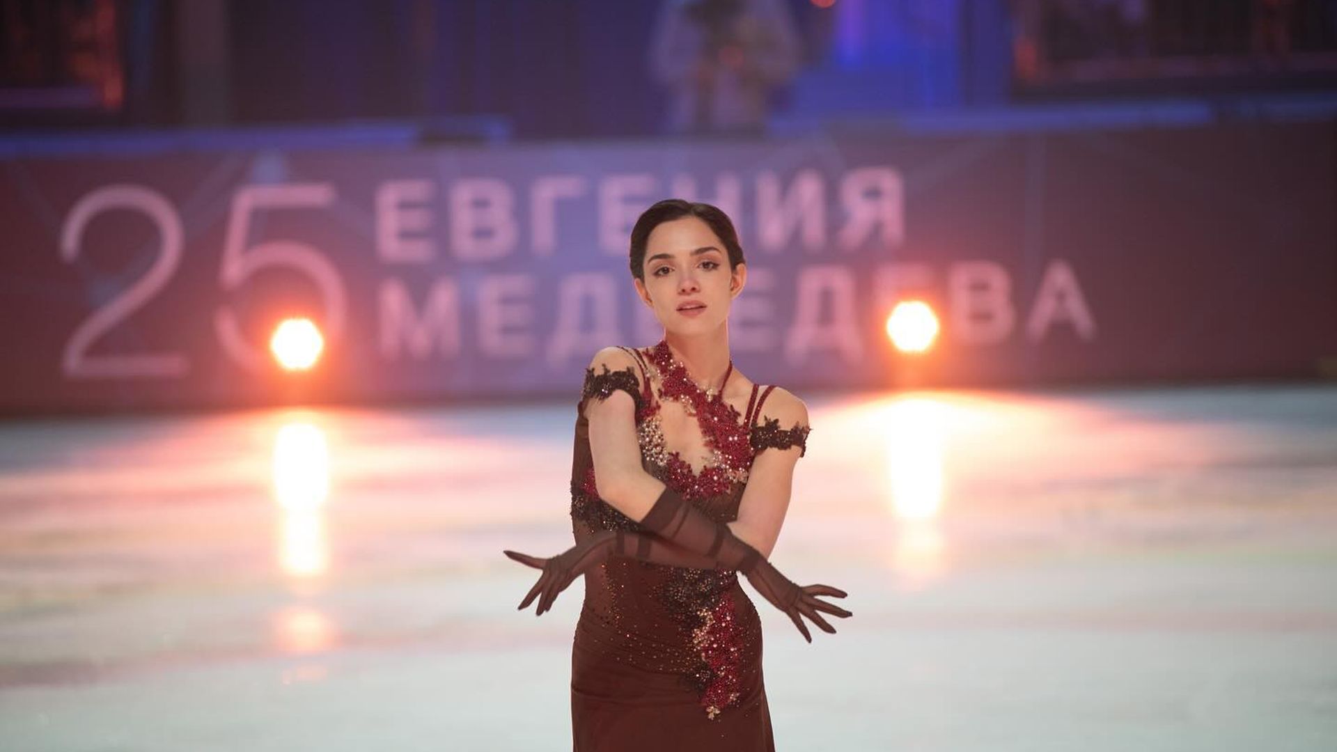 Evgenia Medvedeva performs on ice in a burgundy costume at the show