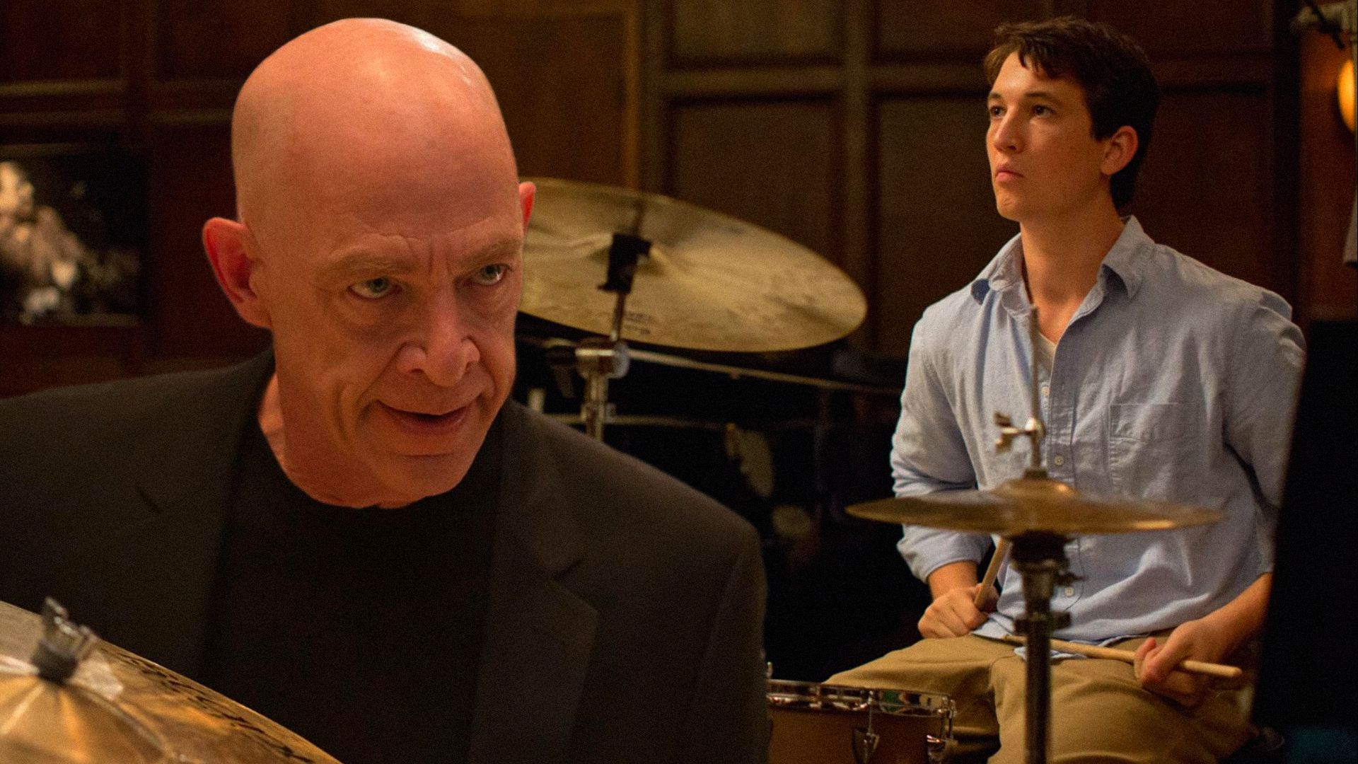 Actor Miles Teller plays behind a drum kit while actor J.K. Simmons glares menacingly down at him
