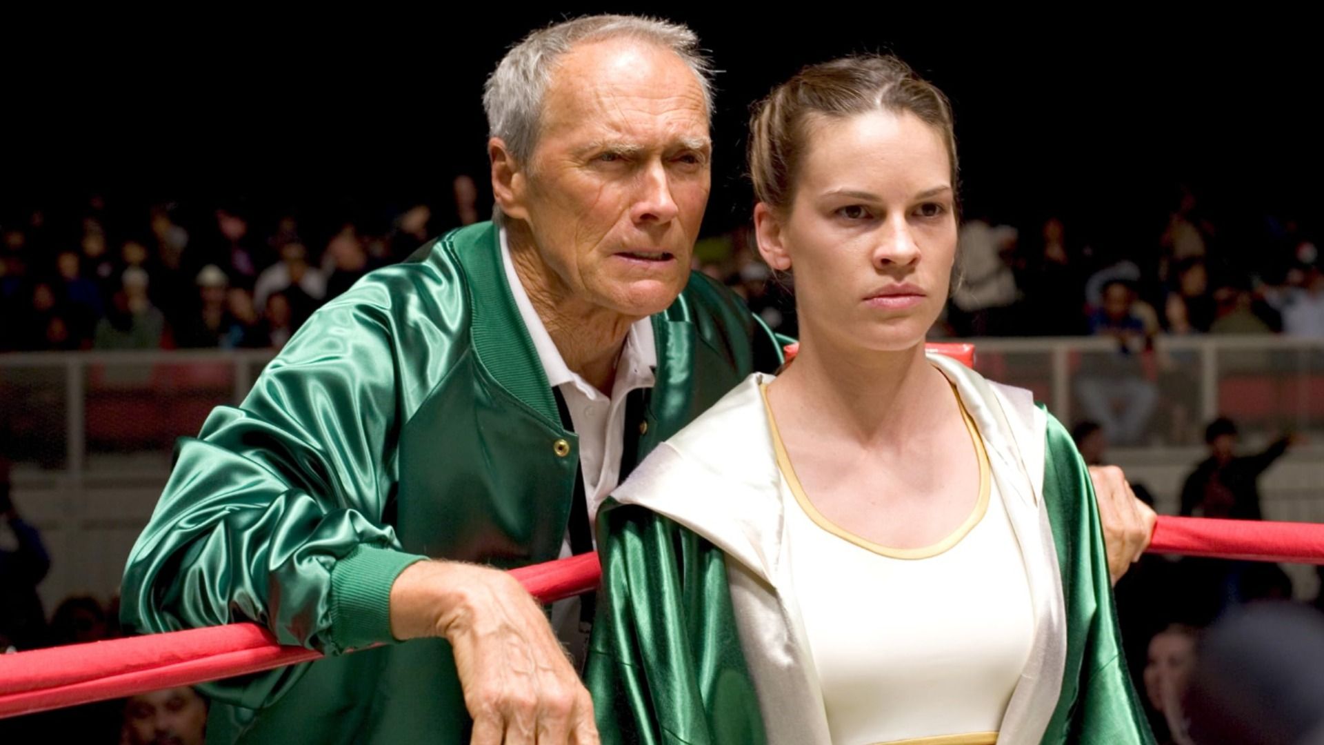 Actors Clint Eastwood and Hilary Swank stand in green clothing on a boxing ring