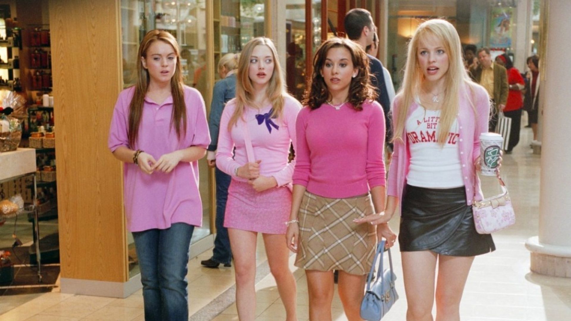 Four girls in pink outfits walk through the shopping mall, standing out with their style and confidence