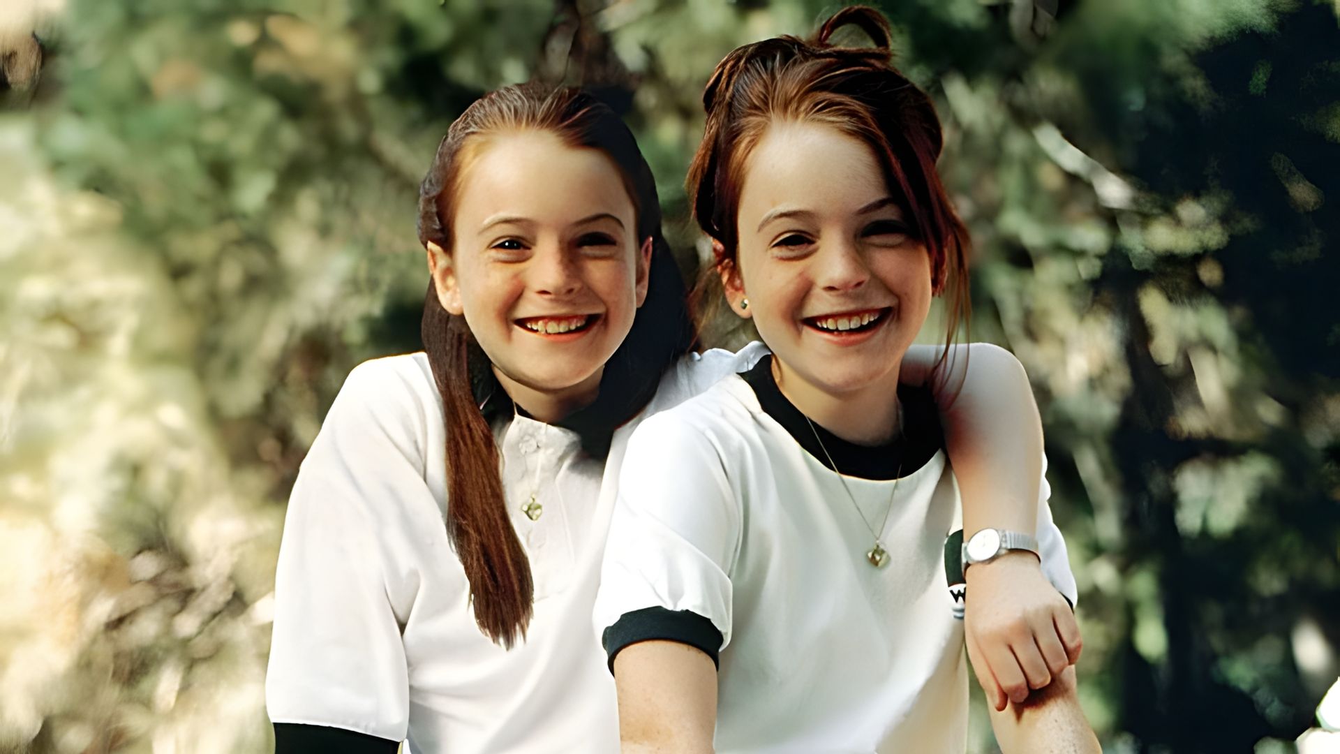 Lindsay Lohan as twins, both wearing white t-shirts against a green background