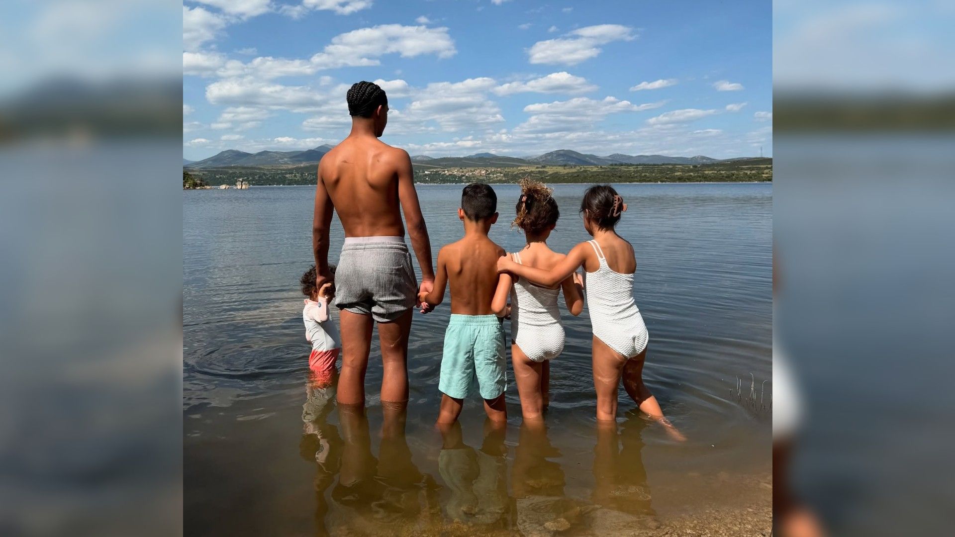 Cristiano Ronaldo's five children standing with their backs to the camera in the water