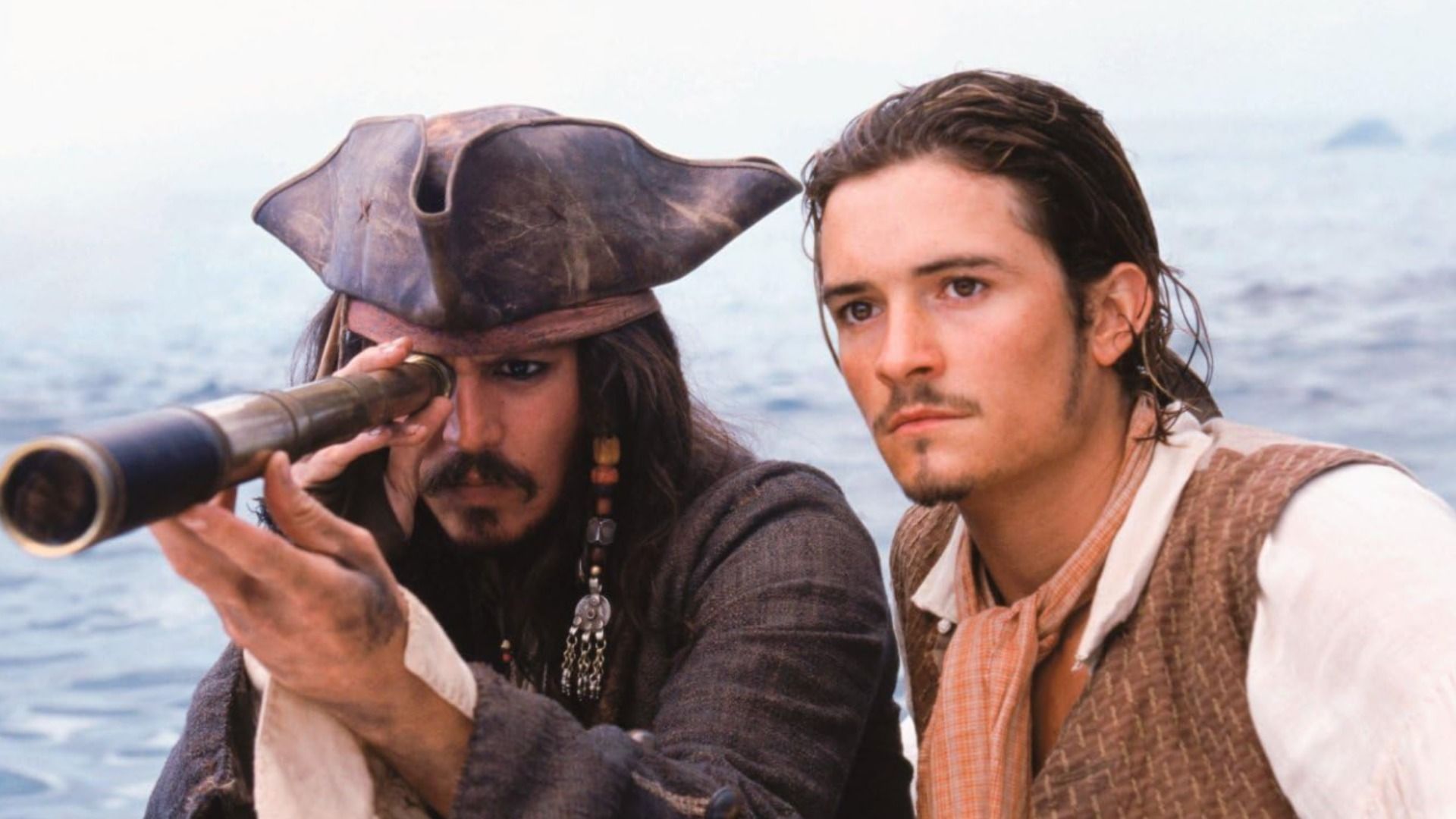 Actor Johnny Depp in a leather tricorn hat and actor Orlando Bloom in a white shirt