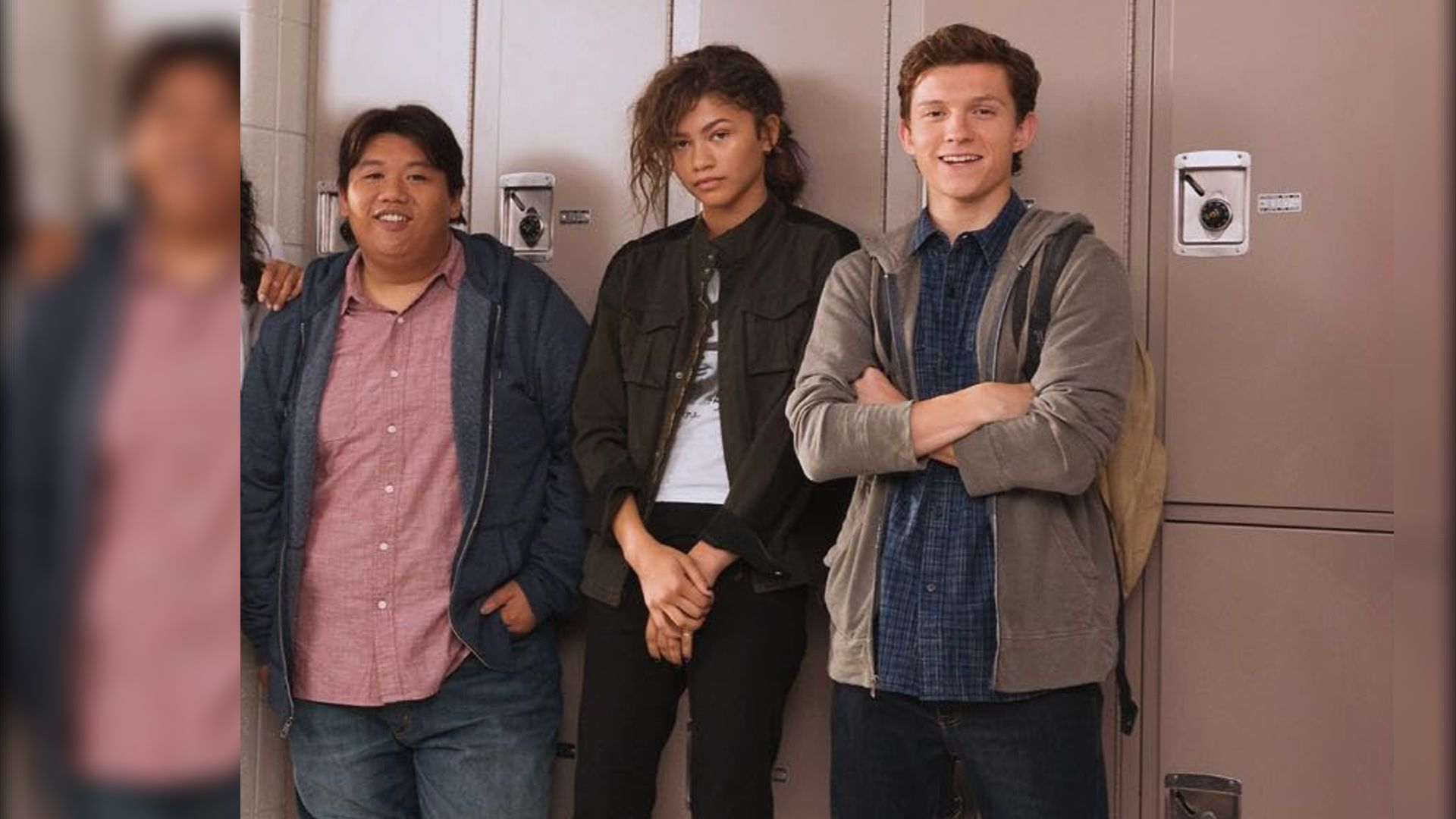 Actors Jacob Batalon, Zendaya and Tom Holland in casual clothes standing by school lockers