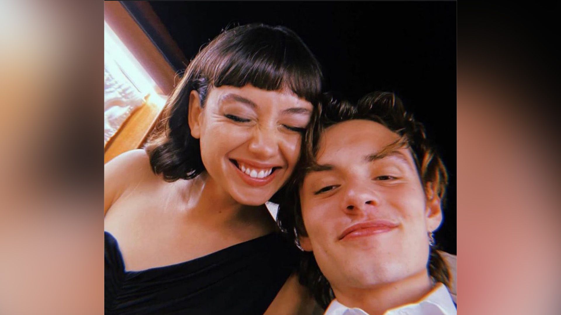 Laughing Sydney Chandler and smiling Louis Partridge