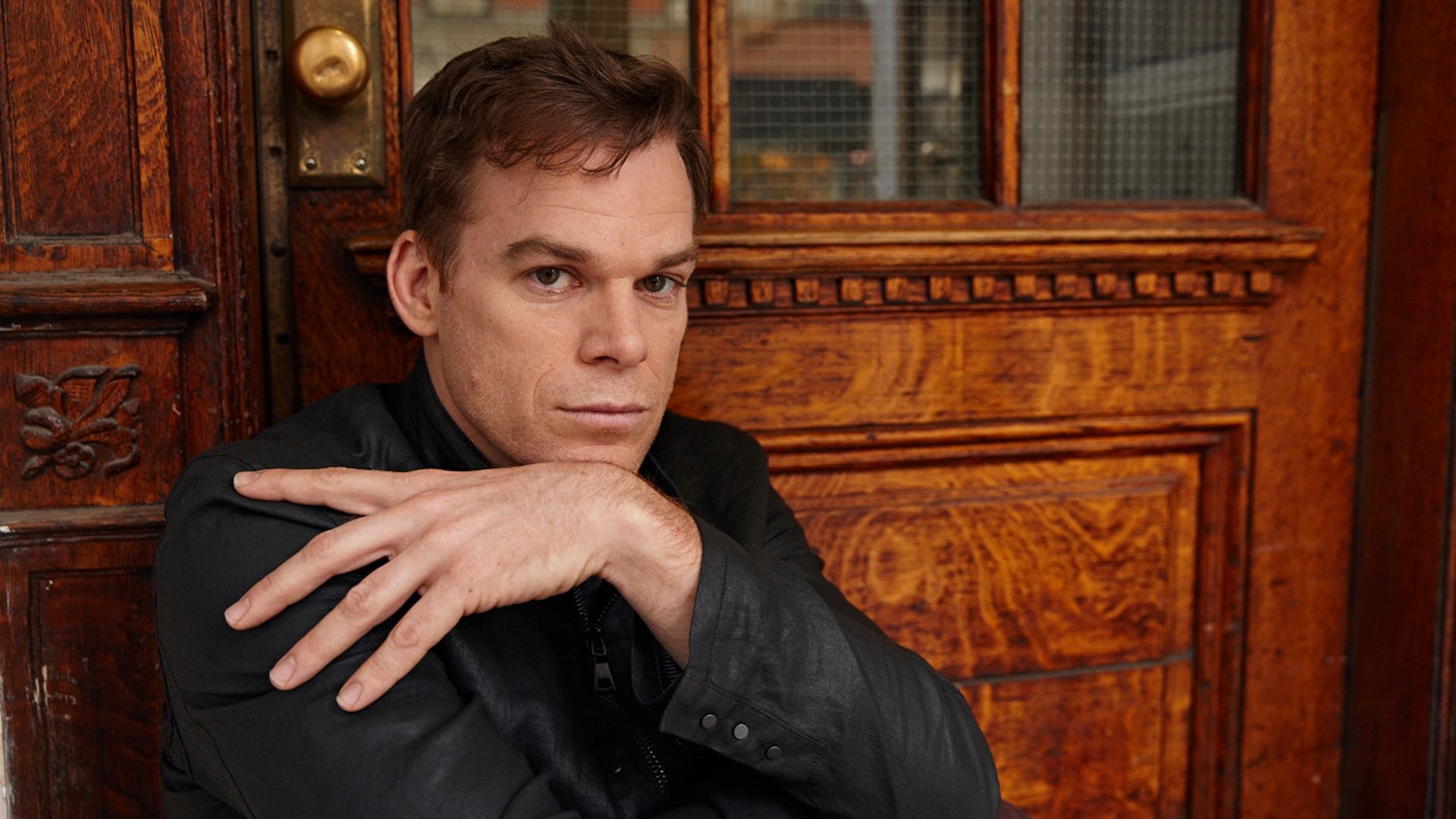 Actor Michael C. Hall poses against a wooden door