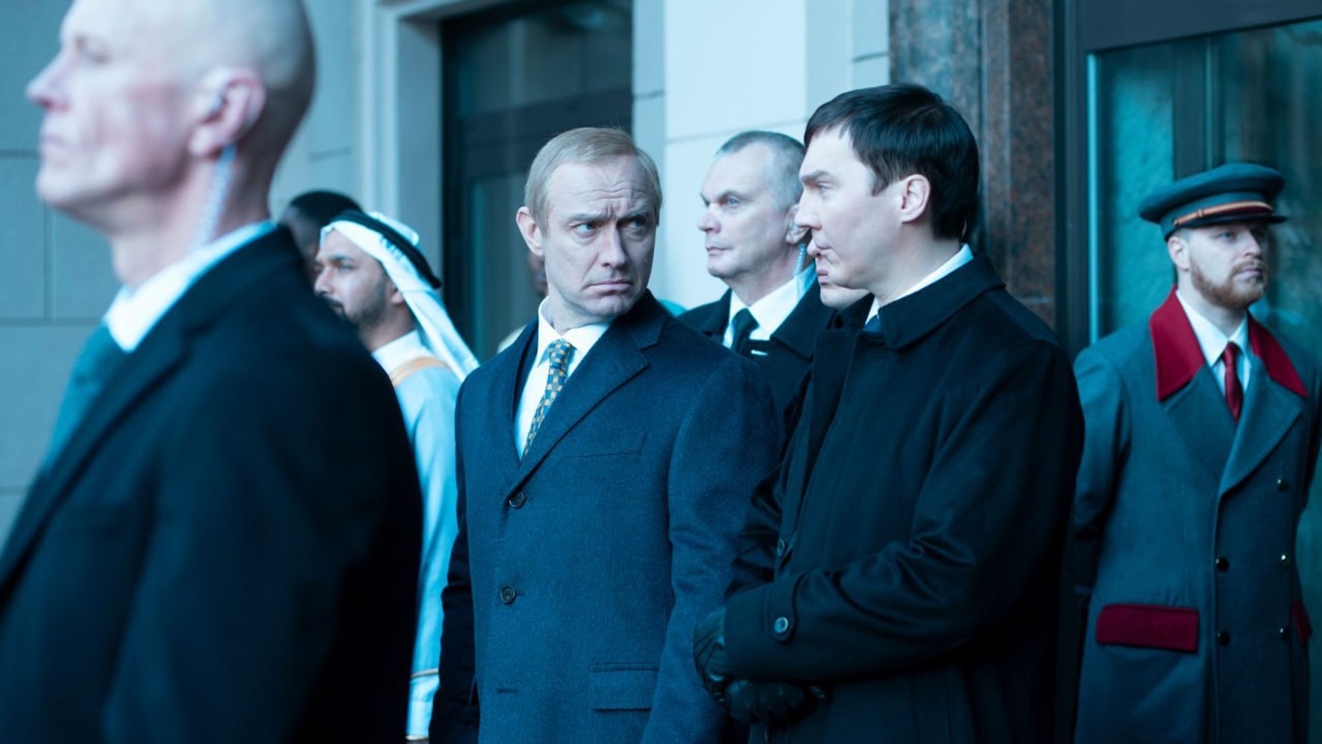 Jude Law and Paul Dano in suits having a serious conversation