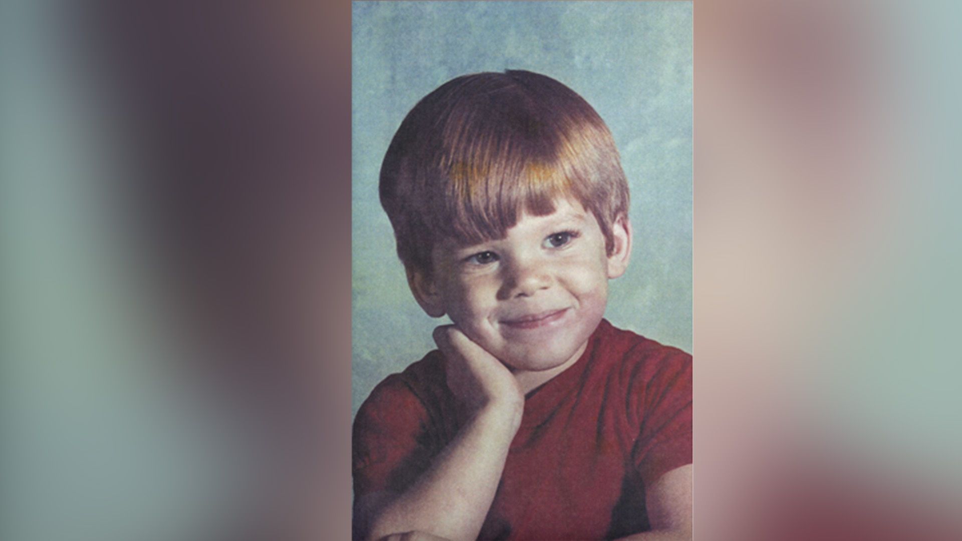 Michael C. Hall as a child in a red shirt looking to the side