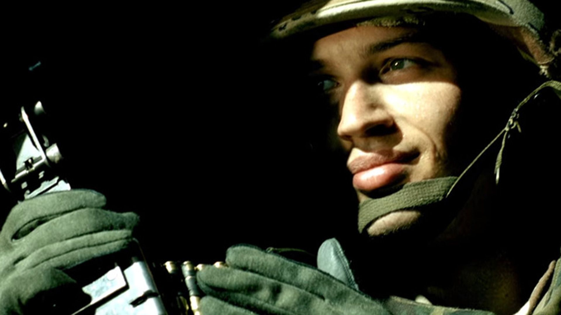 Tom Hardy in military uniform and helmet, face half hidden in shadow