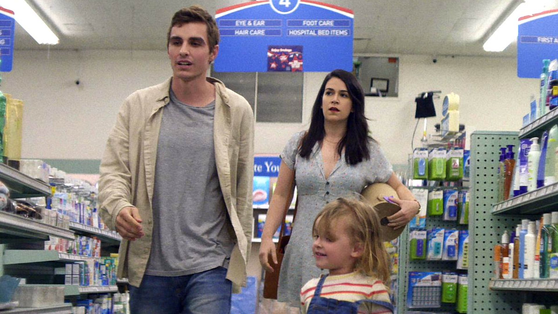 Dave Franco and Abby Jacobson walk through a supermarket, a scene from "6 Balloons"