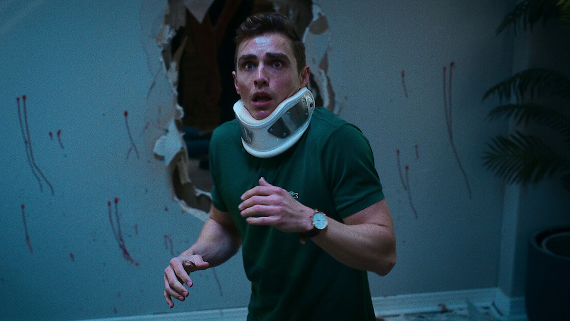 Dave Franco with an orthopedic neck collar and a frightened expression on his face