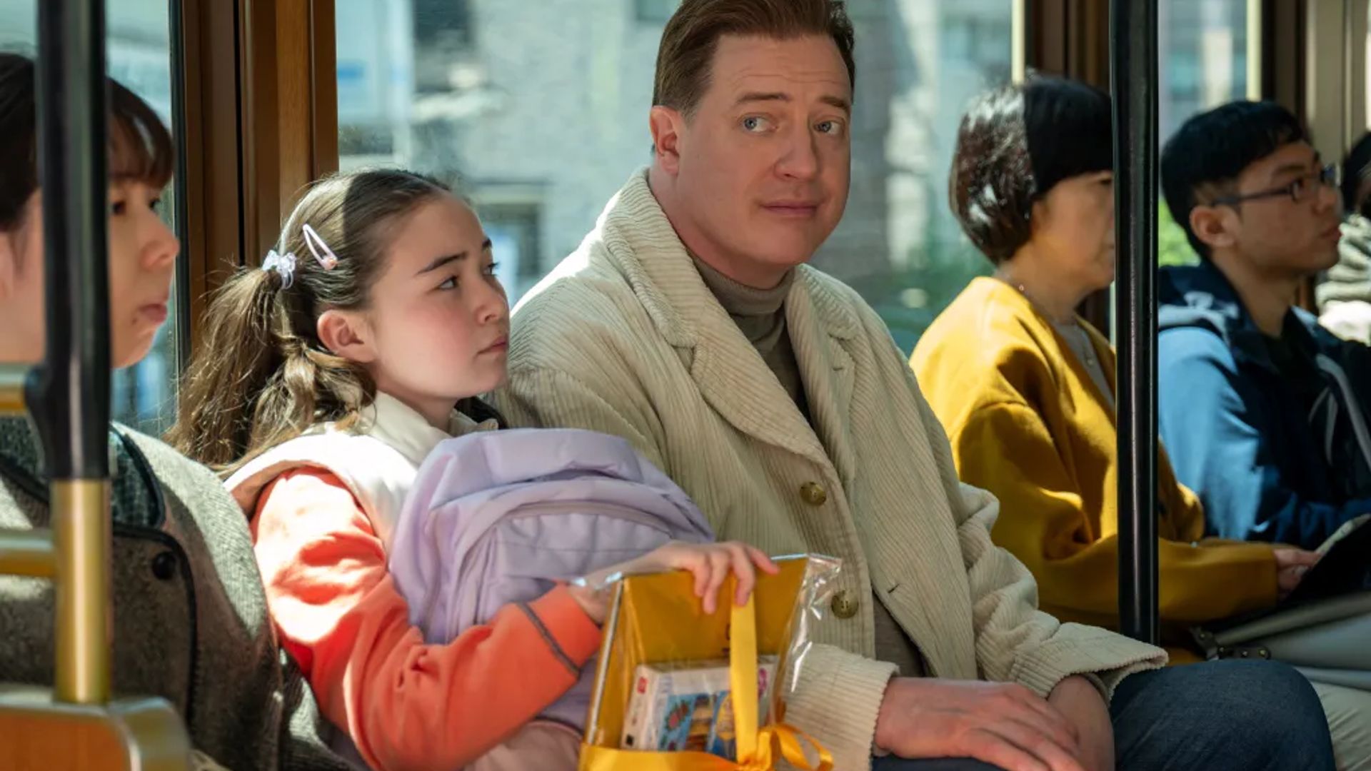 Brendan Fraser rides with a girl on the Tokyo subway