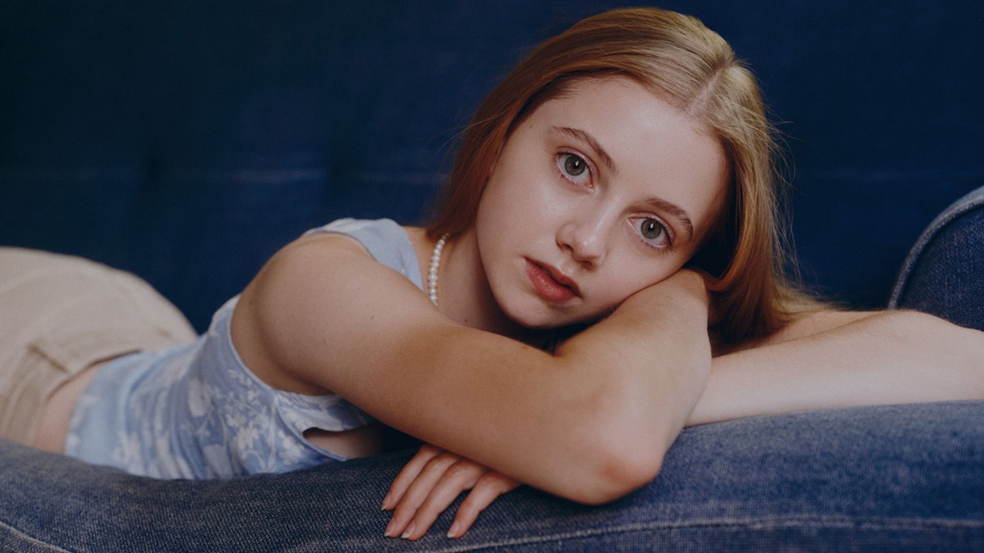 Evie Templeton lying on a couch on her stomach, resting her head on her hands