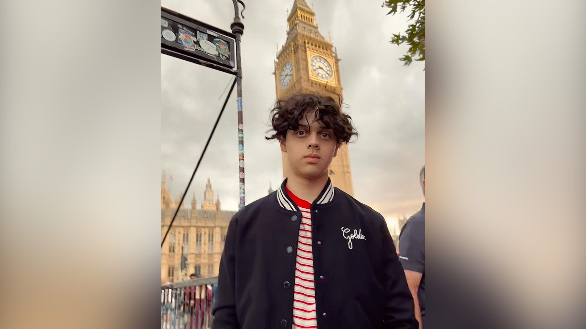 Isaac Ordonez in a blue baseball jacket against the backdrop of Big Ben clock tower in London