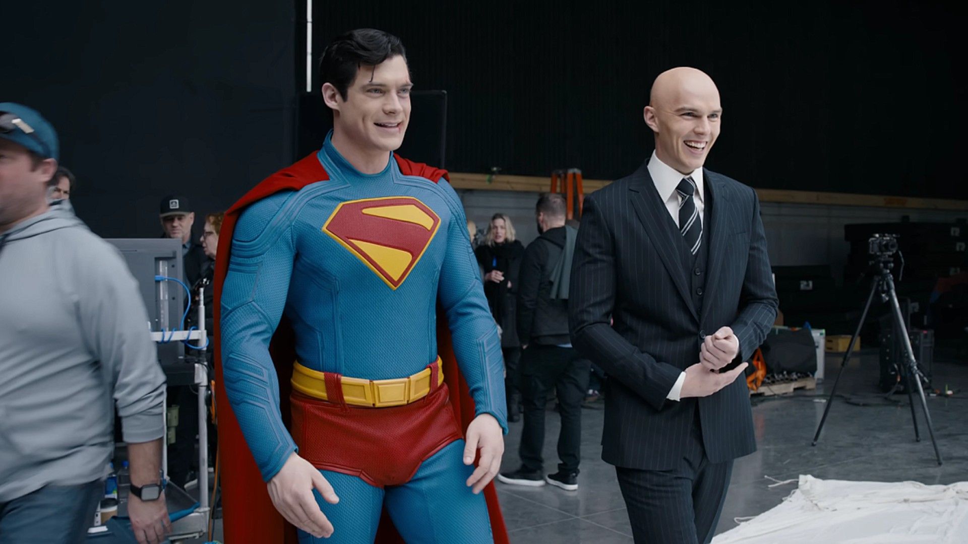 Nicholas Hoult in a black suit and David Corenswet in a Superman costume with a red cape