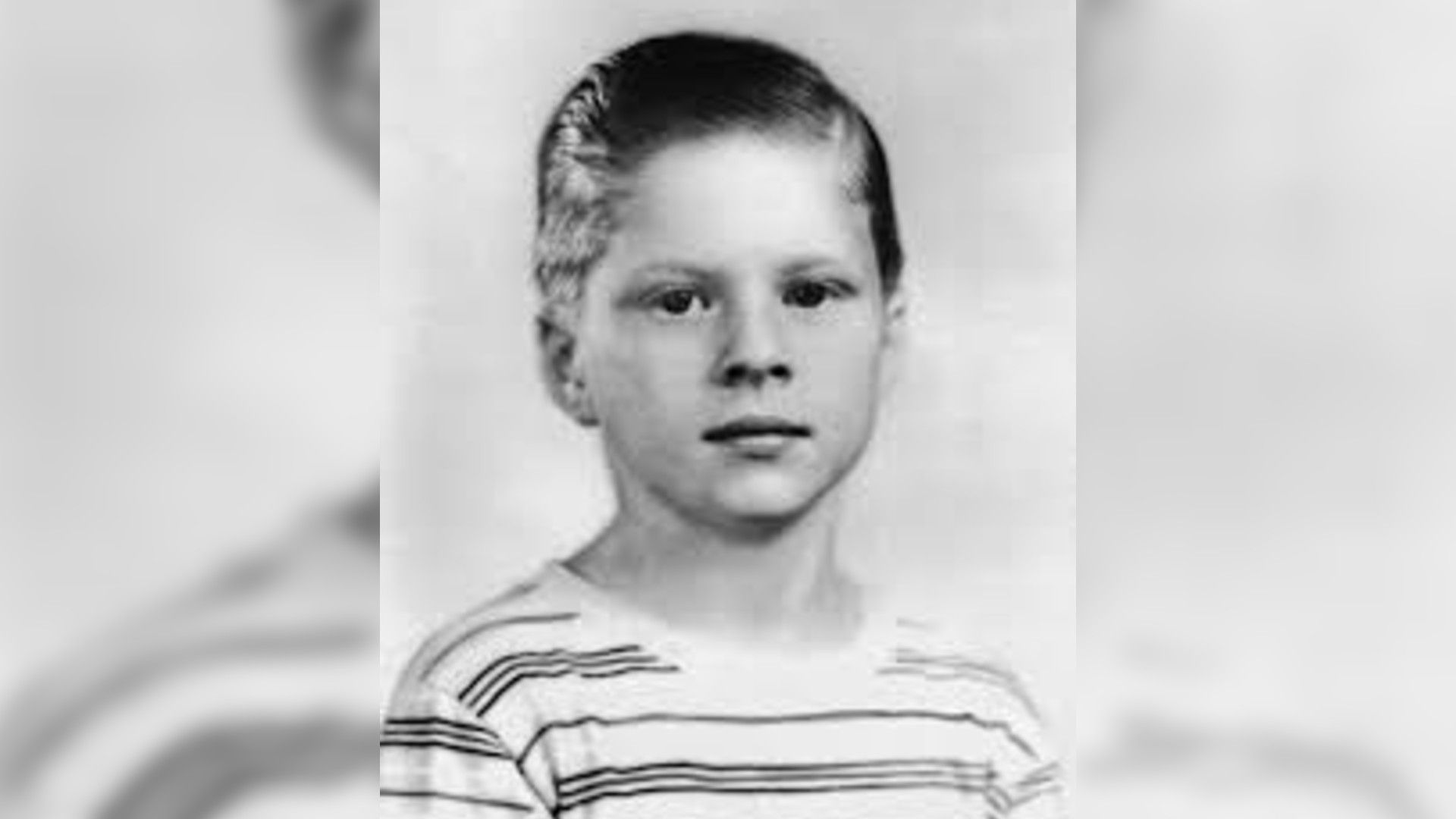 Robert Redford as a child in a striped shirt with a short neat haircut, black and white photo