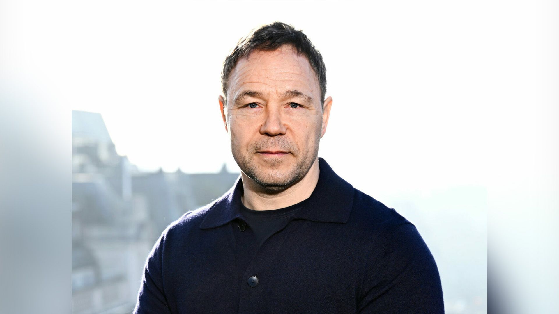 Actor Stephen Graham in a black sweater against a white background