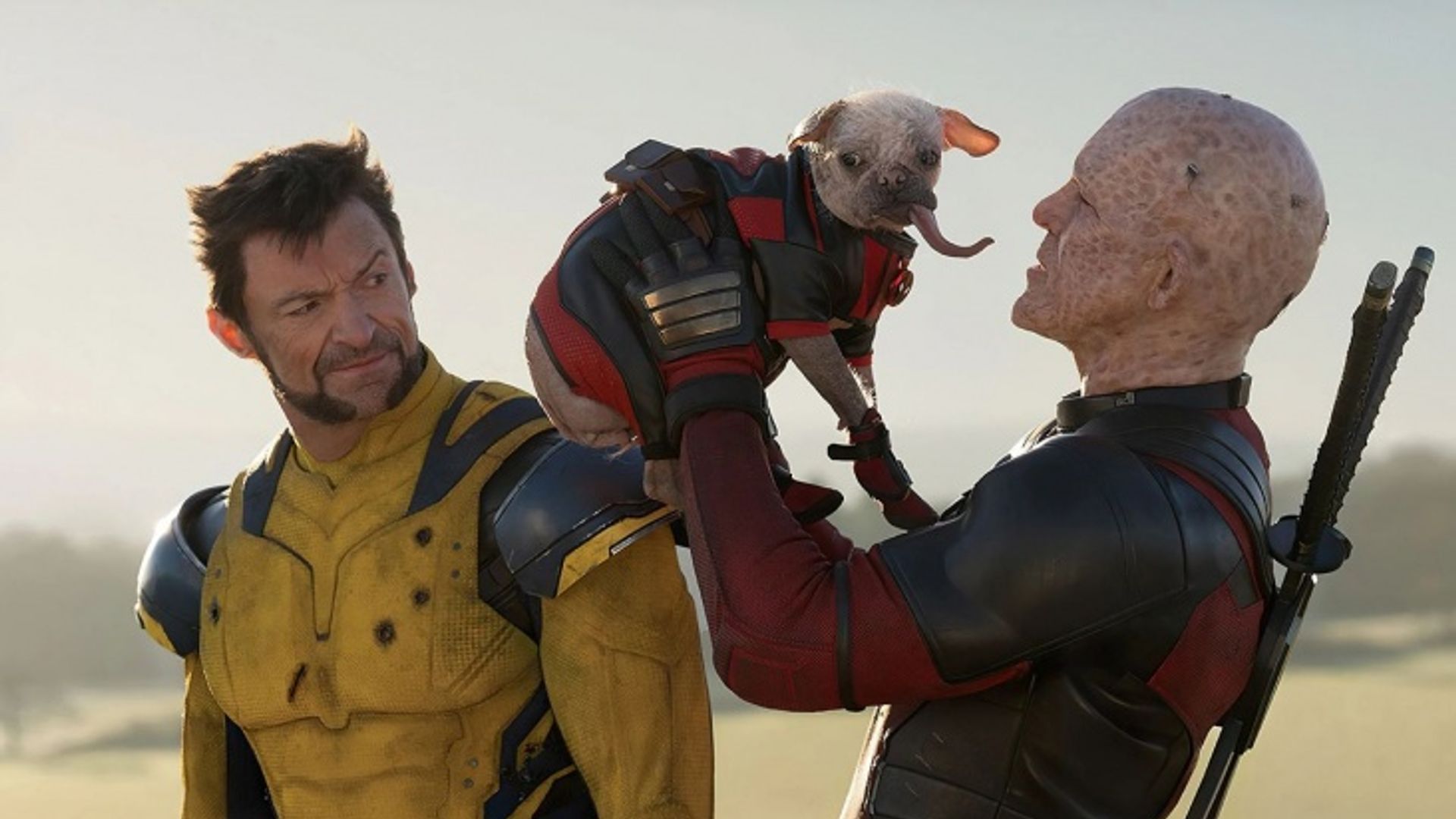 Deadpool holding a dog in costume while Wolverine in his yellow suit looks at them with surprise