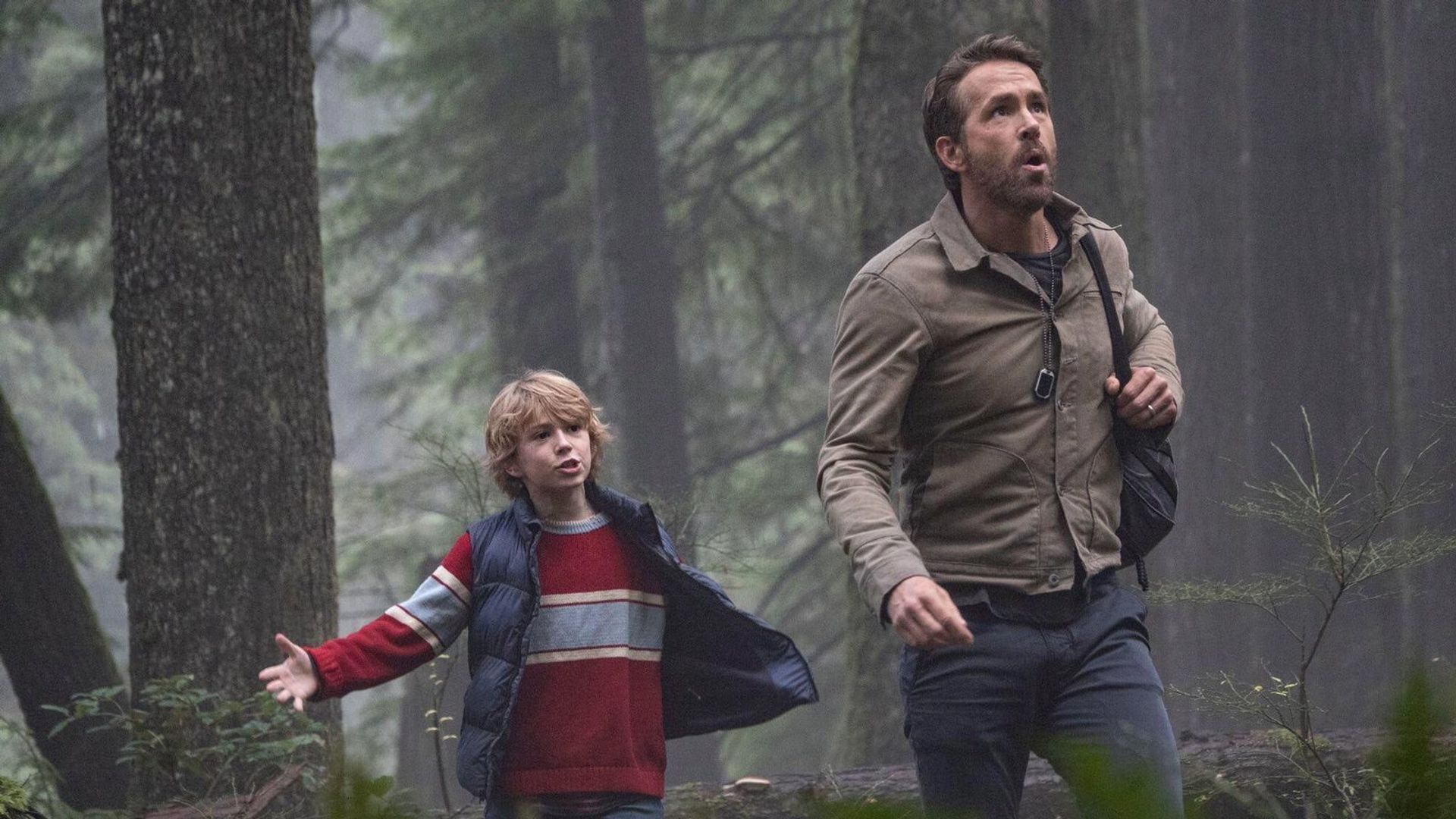 Ryan Reynolds and Walker Scobell walking through the forest and talking