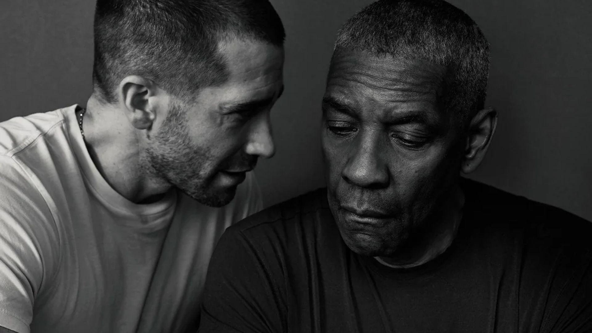 Jake Gyllenhaal and Denzel Washington in a black and white portrait: one is speaking while the other looks down with a thoughtful expression