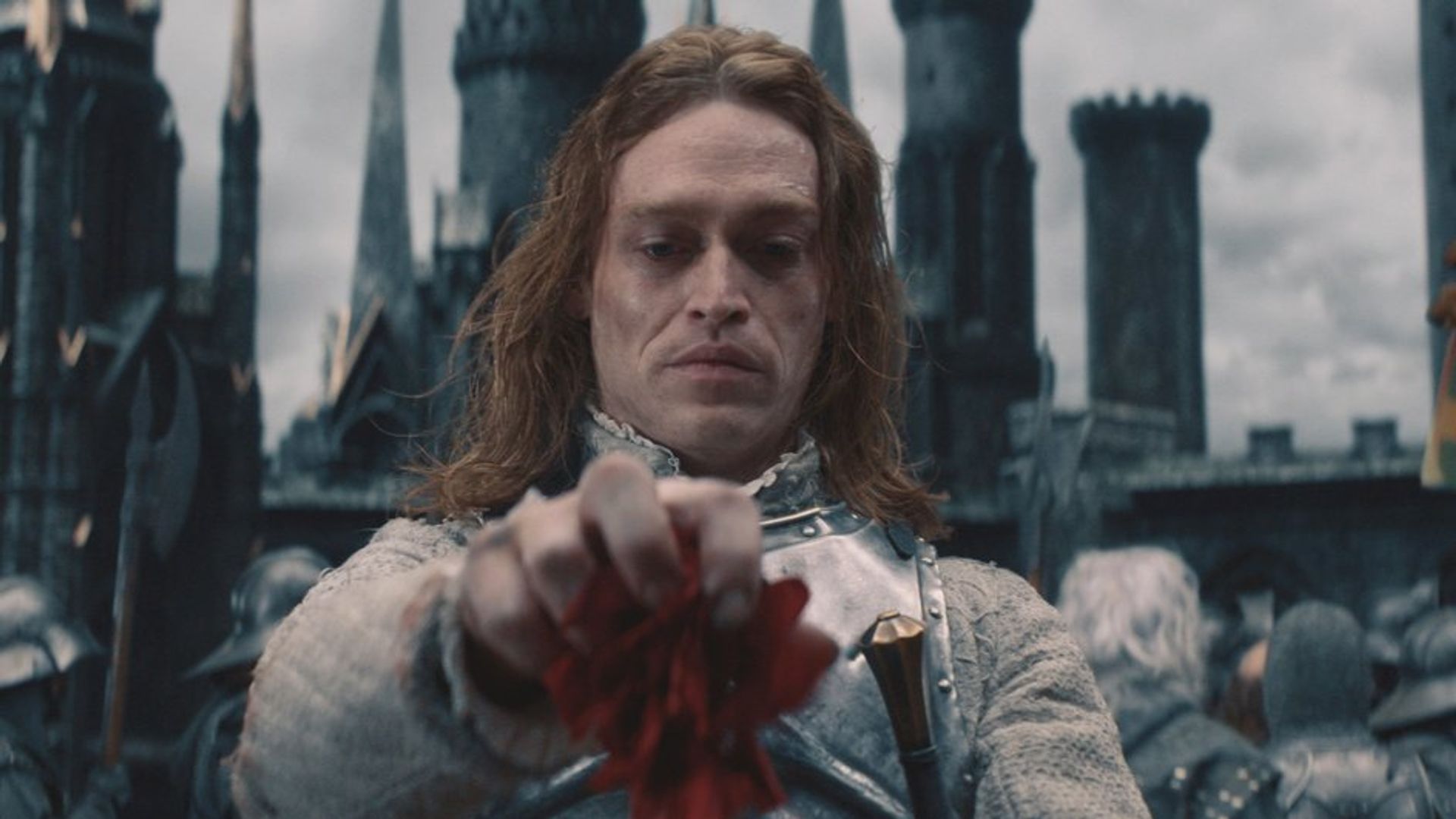 Caleb Landry Jones in vampire makeup looks down with contempt