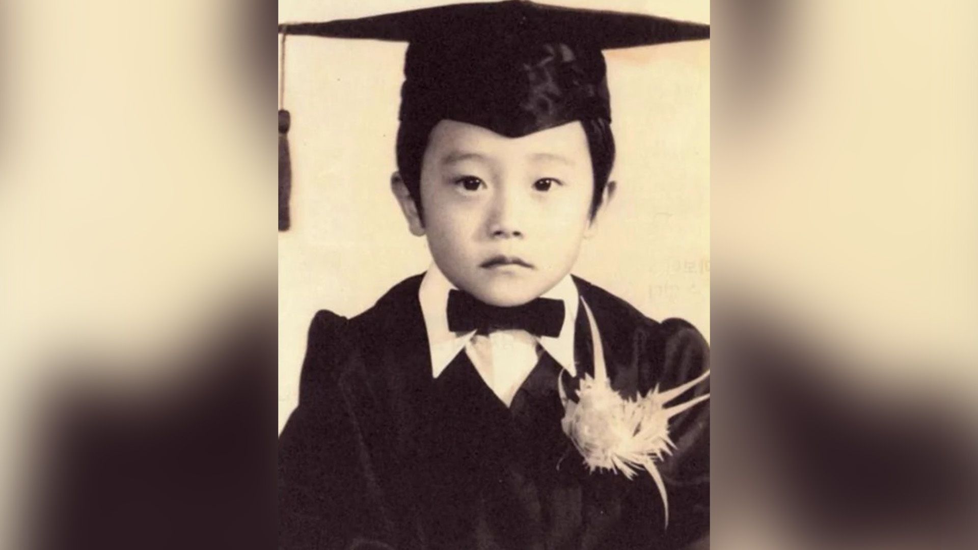 Lee Byung-hun as a child wearing a bow tie and graduation cap