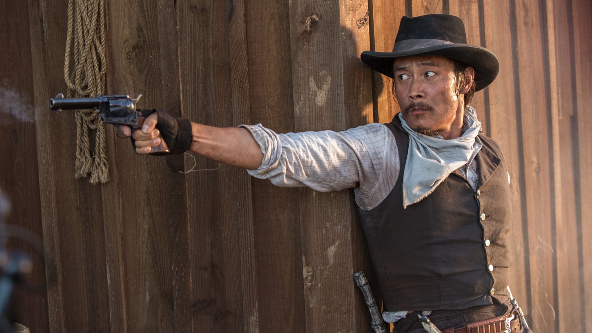 Lee Byung-hun in cowboy outfit and hat shoots a pistol