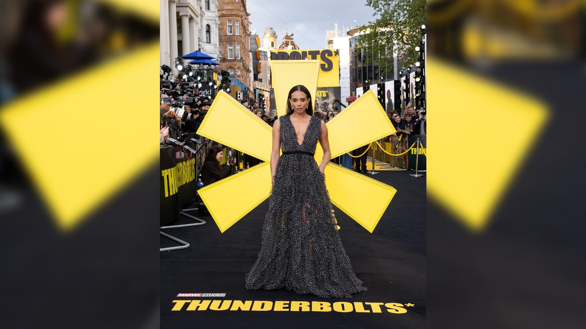 Hannah John-Kamen in a long dress against the backdrop of a huge yellow star