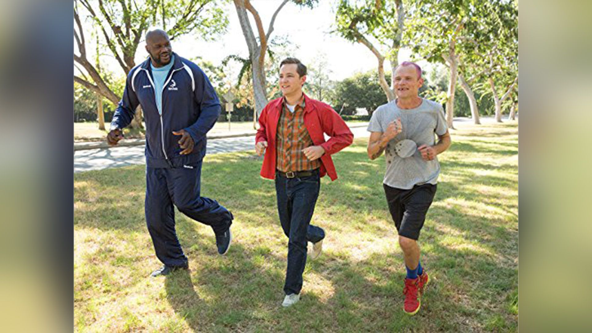 Shaquille O'Neal, Lewis Pullman, and Flea running across a green lawn