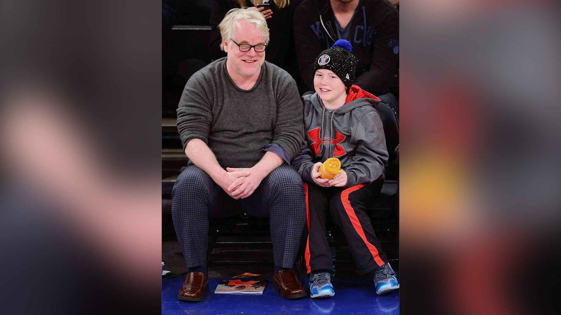 Actor Philip Seymour Hoffman and his young son Cooper Hoffman in the sports stadium stands