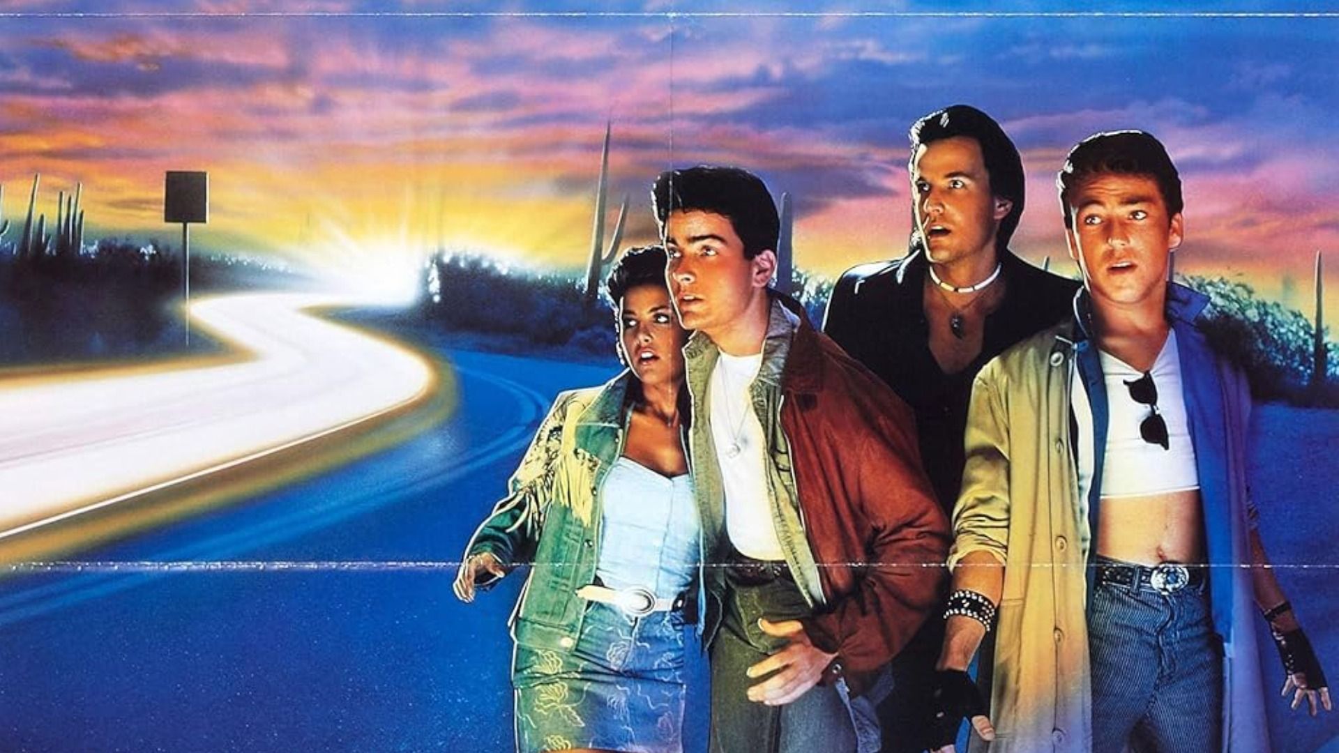 Actor Charlie Sheen in a red jacket standing on the road with a girl and two men