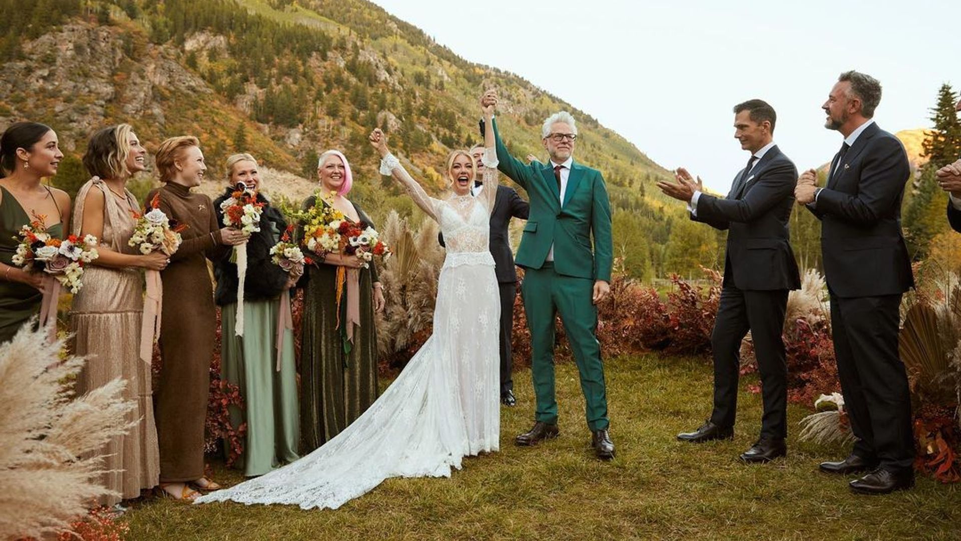 Jennifer Holland and James Gunn in wedding attire against a backdrop of picturesque mountains