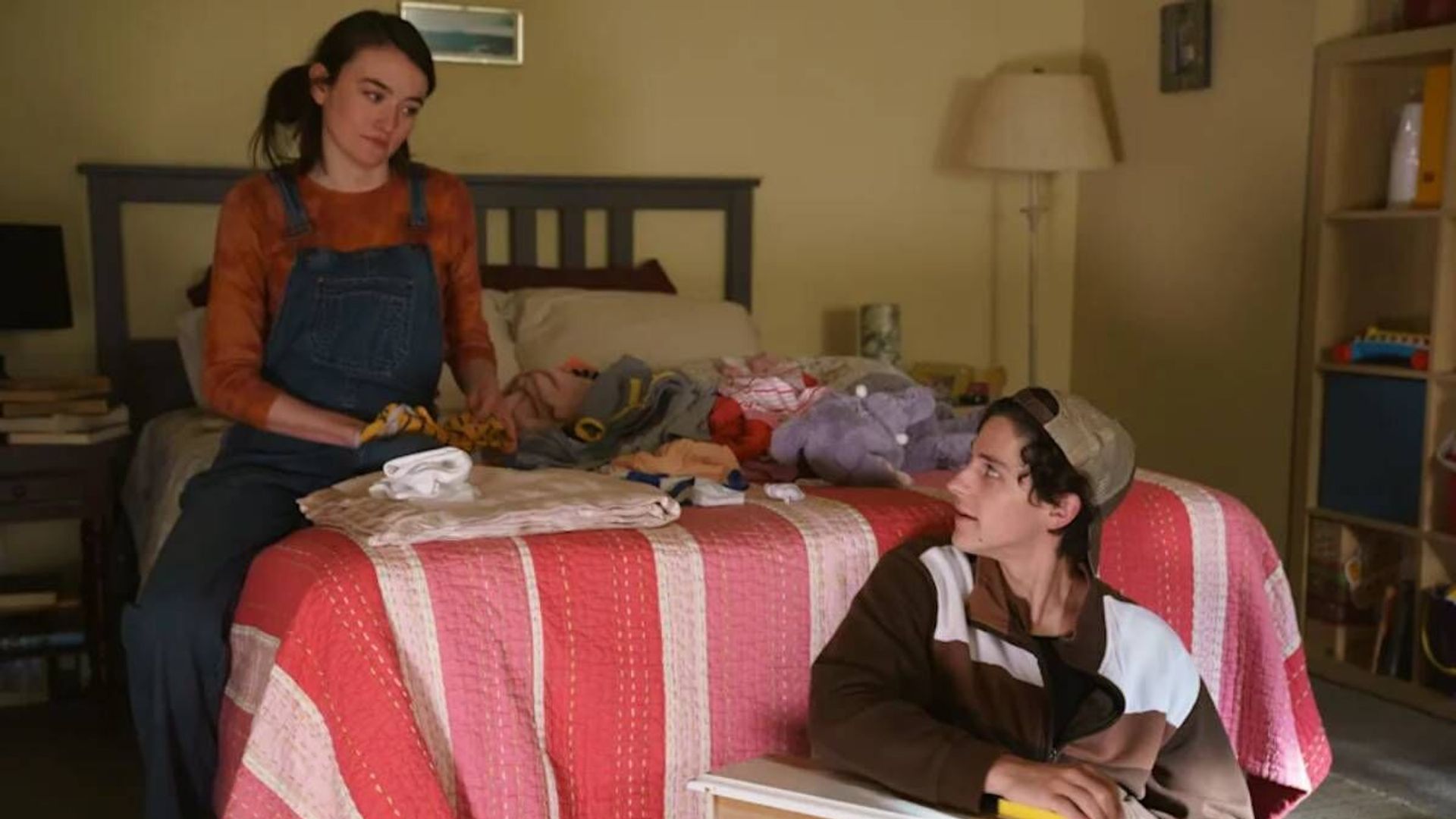 Sarah Pidgeon and Owen Painter sit on a bed, a scene from the series "The Sex Lives of College Girls"